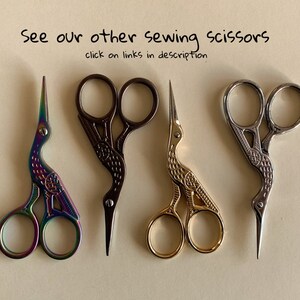 May include: Four pairs of decorative sewing scissors with bird-shaped handles. The scissors are in different colors: iridescent, black, gold, and silver.