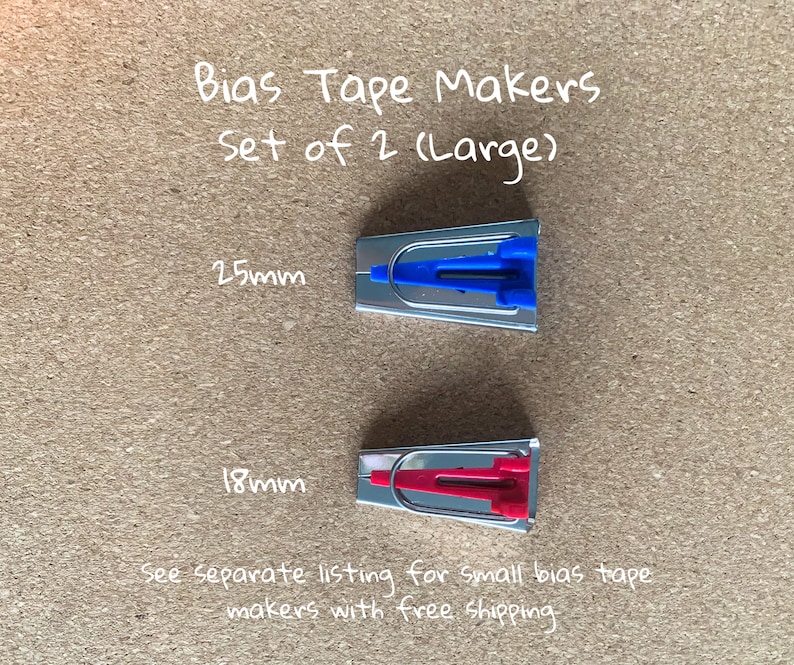 K&ouml;nnte beinhalten: Set mit zwei B&auml;ndermacher, einer blau und einer rot, zum Herstellen von 25 mm und 18 mm B&auml;ndern. B&auml;ndermacher Set mit 2 (gro&szlig;)
