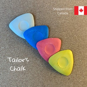 May include: Four triangular tailor's chalk pieces in white, blue, red, and yellow.  The chalk pieces are arranged in a row, with the white chalk piece at the top and the yellow chalk piece at the bottom.  The text "Tailor's Chalk" is written in white below the chalk pieces.