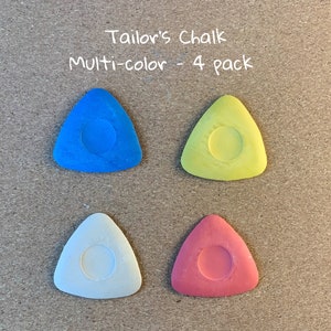 May include: Four triangular tailor's chalk pieces in blue, yellow, white, and red. The chalk is in a 4 pack and labeled "Tailor's Chalk Multi-color - 4 pack".