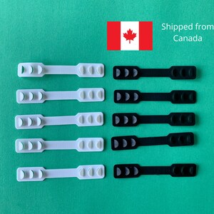 May include: Set of 10 white and black ear savers for face masks. The ear savers are made of a soft, flexible material and have three bumps on each side. They are designed to help reduce ear pain from wearing a face mask for long periods of time.