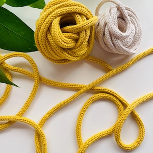 May include: A white ceramic mug with a black handle and the text "But First, Coffee" in a black, handwritten-style font. The mug is on a white surface.