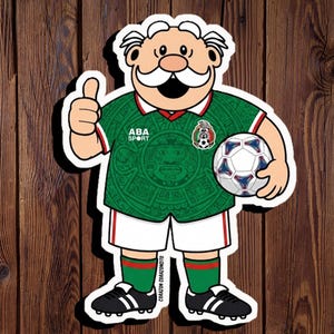 May include: A cartoon sticker of an elderly character with a white mustache wearing a green soccer jersey with the text ABA SPORT and the Mexico national team crest, white shorts, green socks, and black cleats, holding a white and blue soccer ball.