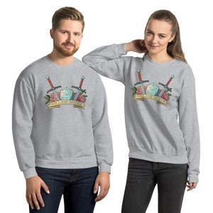 Könnte beinhalten: Zwei graue Sweatshirts mit einem grafischen Design aus einem blauen 20-seitigen Würfel, zwei Schwertern und roten Rosen. Der Banner lautet "Roll for Gender".