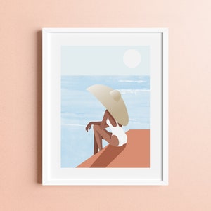 May include: A woman wearing a white swimsuit sits on a terracotta-colored ledge, looking out at the ocean. She is wearing a large, white sun hat.