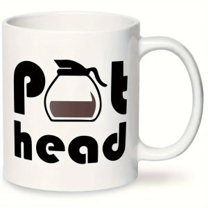 May include: White ceramic coffee mug with a black graphic of a coffee pot and the text "pot head".