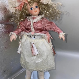 Porcelain small doll Gigi’s daughter by  Franklin heirloom,numbered , soft body in pink dress
