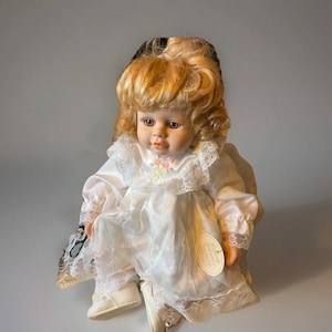 Large seated  porcelain girl  doll with soft body,tag