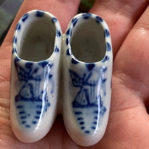 May include: Pair of miniature blue and white ceramic Dutch clogs with a windmill design.
