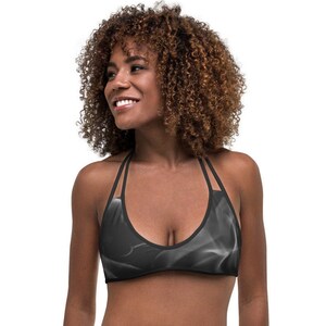 Peut inclure: Un haut de bikini noir à halter avec un motif de fumée blanche. Le haut a des bretelles réglables et une fermeture à nouer dans le dos.