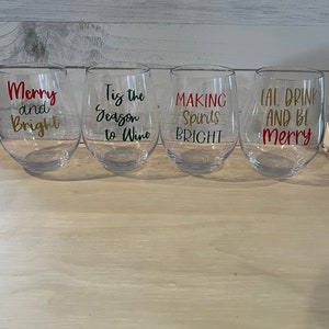 K&ouml;nnte beinhalten: Vier klare, stielose Weingl&auml;ser mit festlichen Texten in Rot, Gold und Gr&uuml;n. Die Gl&auml;ser tragen die Aufschriften: "Merry and Bright", "Tis the Season to Wine", "Making Spirits Bright" und "Eat, Drink and Be Merry".