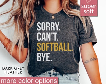 May include: A dark grey heather t-shirt with the text "SORRY. CAN'T. SOFTBALL. BYE." printed in white and yellow. The shirt is super soft and comfortable.