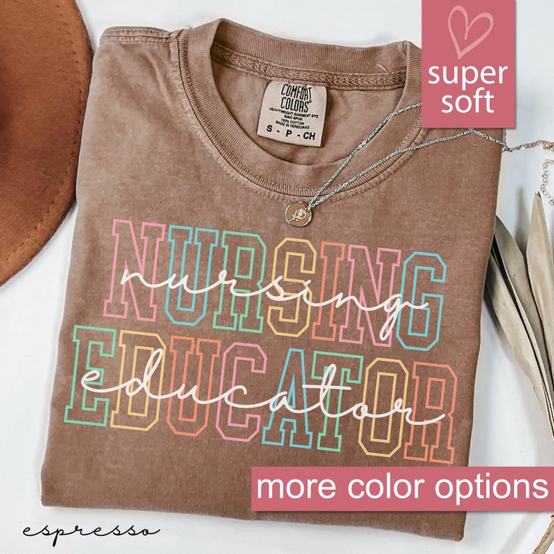 Puede incluir: Una camiseta marr&oacute;n con el texto "Nursing Educator" en colores arco&iacute;ris. El texto est&aacute; contorneado en negro. La camiseta es s&uacute;per suave y tiene un aspecto desgastado. El texto "espresso" est&aacute; en la parte inferior de la imagen.