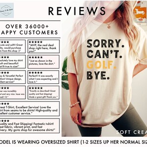 May include: A white t-shirt with the text "SORRY. CAN'T. GOLF. BYE." printed in black and yellow. The shirt is oversized and being worn by a model. The model is wearing green shorts and a silver bracelet. The text "MODEL IS WEARING OVERSIZED SHIRT (1-2 SIZES UP HER NORMAL SIZE)" is printed at the bottom of the image.