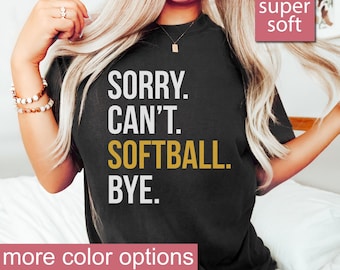 Puede incluir: Camiseta negra con texto blanco que dice "SORRY. CAN'T. SOFTBALL. BYE." El texto "SOFTBALL" está en dorado. La camiseta es súper suave y tiene más opciones de color.