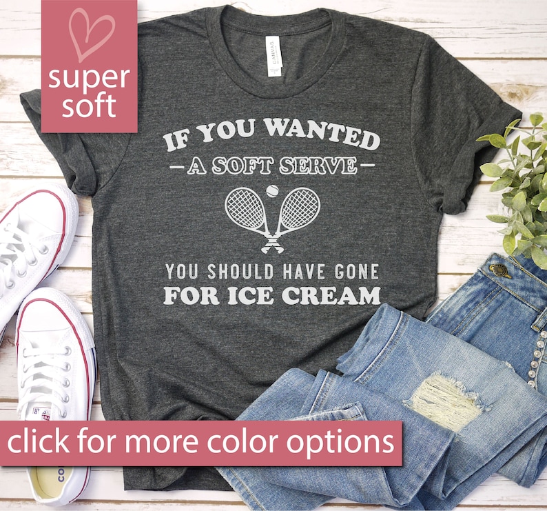 Puede incluir: Una camiseta gris con un gr&aacute;fico blanco que dice "Si quer&iacute;as - un servicio suave - deber&iacute;as haber ido por helado". El gr&aacute;fico tambi&eacute;n incluye una raqueta de tenis y una pelota.