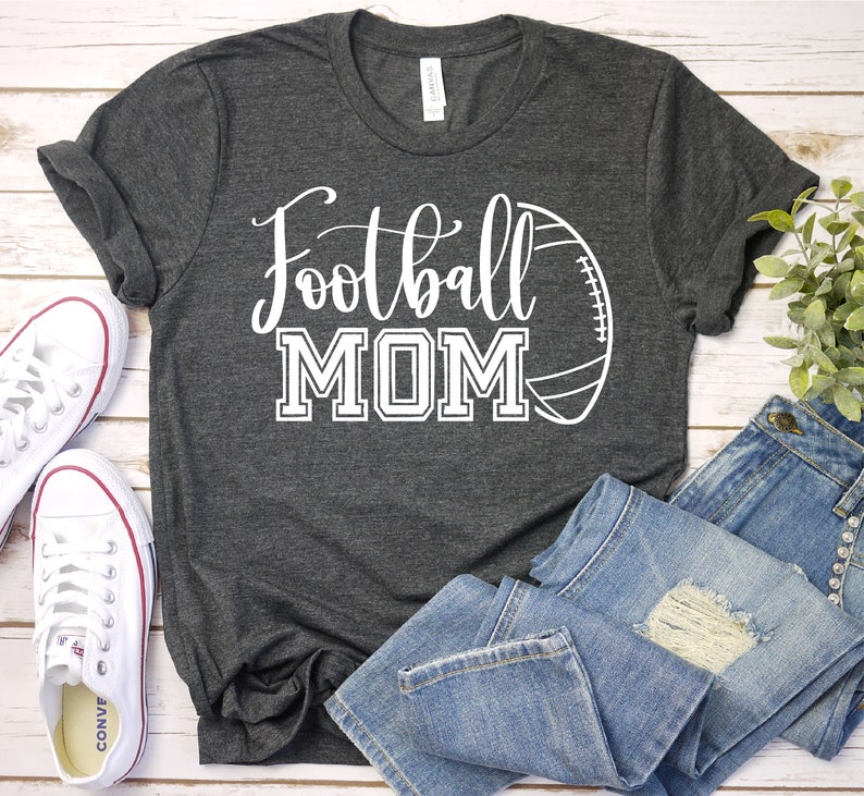 May include: A gray t-shirt with the text "Football MOM" in white lettering and a white outline of a football.