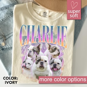 May include: Ivory-colored t-shirt featuring the name "CHARLIE" in a gradient font, with images of French Bulldogs. The shirt has a "super soft" label and the words "more color options" are displayed.