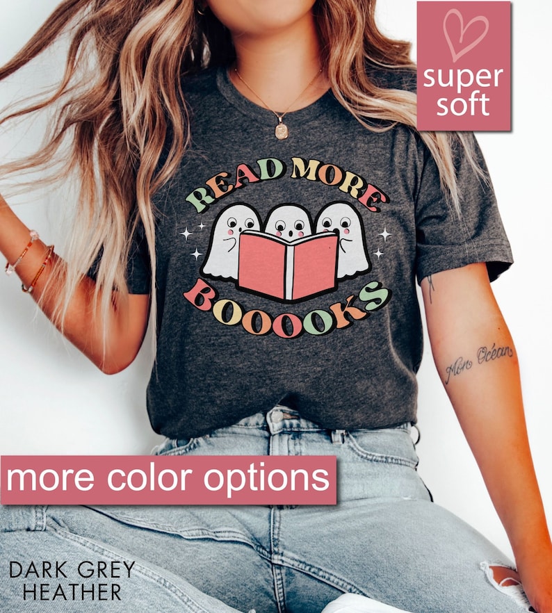 May include: A dark grey heather t-shirt with a graphic of three ghosts reading a book. The text on the shirt reads "Read More Booooks".