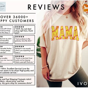 May include: A white t-shirt with the word "MAMA" printed in yellow letters with a softball design. The softball is yellow with red stitching. The t-shirt is being worn by a person. The background is a light brown wall with a picture of a horse on it. The text "IVORY" is printed in black at the bottom of the image.