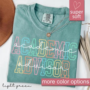 May include: Light green t-shirt with the text "academic advisor" in rainbow colors. The shirt is made of a soft, comfortable fabric.