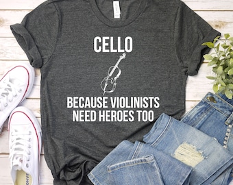 Camisa para violoncelo porque os violinistas também precisam de heróis – Camisa para violoncelo, moletom com capuz para violoncelo, camisa para violoncelista, presente para músico, camisa premium masculina e feminina unissex