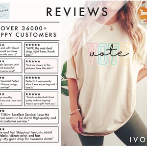 May include: A white t-shirt with a rainbow colored "vote" graphic. The t-shirt is being worn by a person with long blonde hair. The person is wearing green shorts and a gold bracelet. The background is a light brown wall with a book on a shelf.