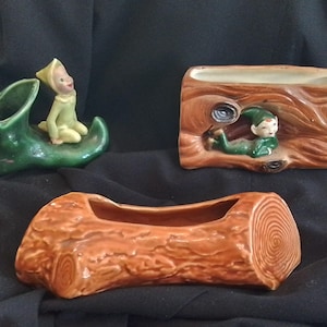 Può includere: Tre fioriere in ceramica con un tema stravagante. Una è una scarpa verde con un elfo, un'altra è un tronco con un elfo, e la terza è una fioriera a forma di tronco. Le fioriere sono marroni, verdi e beige.