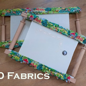 May include: A wooden embroidery hoop with white fabric stretched across it. The hoop is decorated with a colourful fabric featuring a pattern of animals and plants. The text "60 FABRICS" is visible in the bottom left corner of the image.
