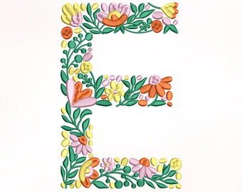 Può includere: Una lettera E floreale con fiori rosa, arancioni, gialli e verdi. La lettera è fatta di fiori e foglie ricamate.