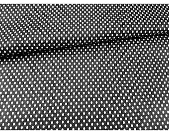 May include: Black fabric with a repeating pattern of small, evenly spaced white polka dots. The fabric is slightly draped, creating shadows and texture. The polka dots are consistent in size and shape, covering the entire surface.