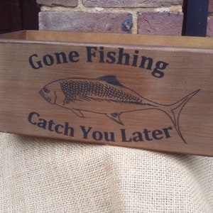 May include: A wooden box with the text "Gone Fishing Catch You Later" and a silhouette of a fish.
