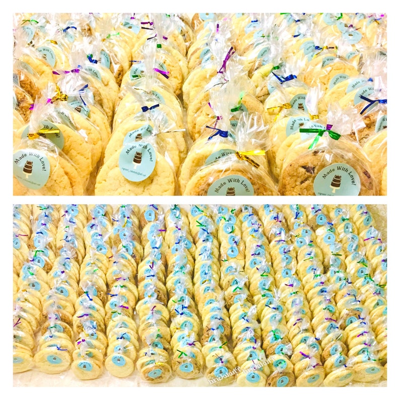 May include: A large quantity of individually packaged sugar cookies, each with a blue and white sticker that says "Made with Love!" The cookies are arranged in rows and columns on a white surface.