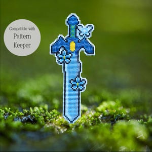 May include: A cross-stitch design of a blue sword with floral and butterfly accents. The sword has a yellow center and a green handle. The text "Compatible with Pattern Keeper" is in a white circle.