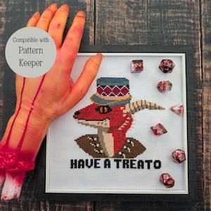 May include: Cross-stitch pattern of a red dragon wearing a hat with the text "Have a Treat, Yo!" and surrounded by red and gold dice. Compatible with Pattern Keeper.