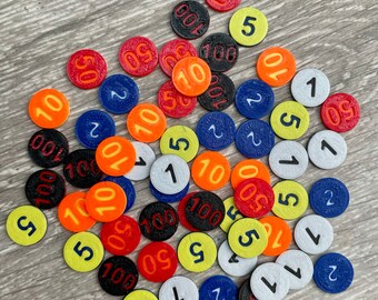 Pode incluir: Uma coleção de peças de jogo redondas e coloridas com números impressos nelas. As peças são em vários tons de vermelho, laranja, amarelo, azul e preto.