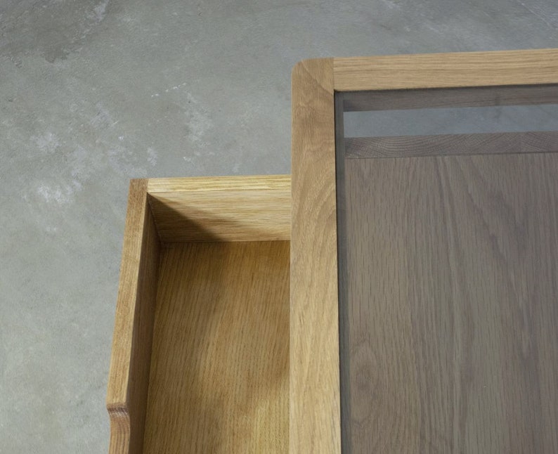 Puede incluir: Una mesa de centro de madera con tapa de cristal y un caj&oacute;n. La mesa est&aacute; hecha de madera marr&oacute;n claro y tiene un acabado natural.