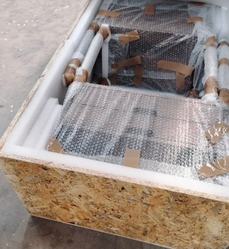 May include: A wooden crate containing a brown cardboard box. The box is wrapped in bubble wrap and secured with brown tape.