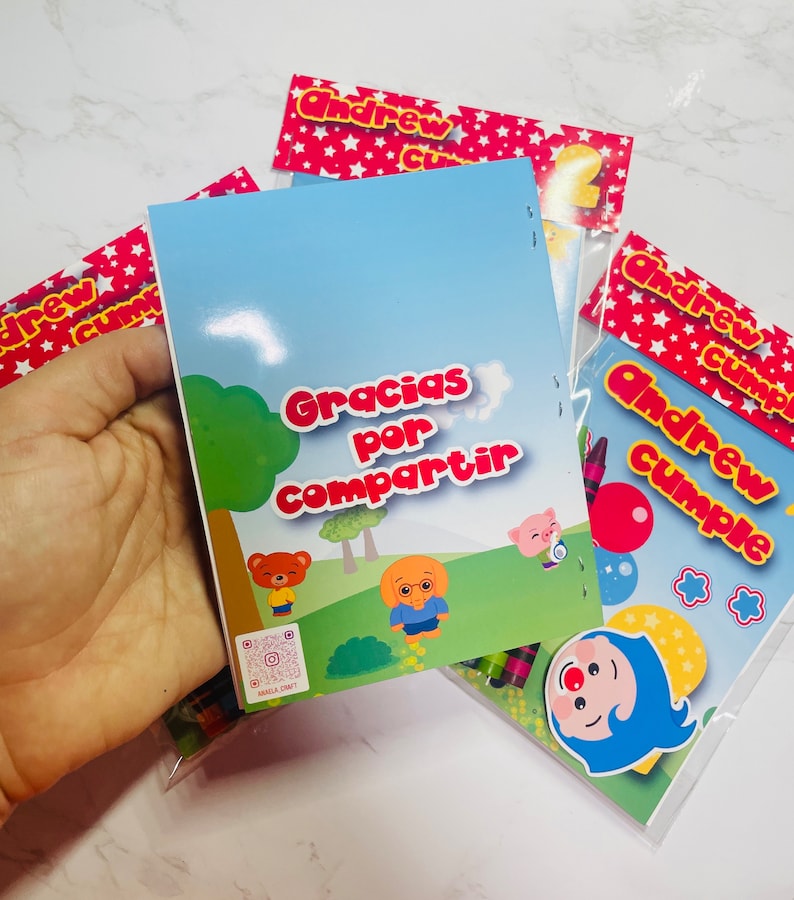 May include: A colourful thank you card with the text "Gracias por compartir" and a cartoon bear and dog. The card is part of a party favour bag with crayons and a clown sticker.