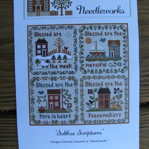 May include: A cross-stitch pattern sheet titled Saltbox Scriptures by Little House Needleworks. It features four square designs with houses, nature elements, and text: Blessed are the meek, Blessed are the merciful, Blessed are the pure in heart, and Peacemakers.