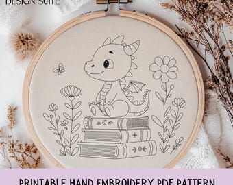 May include: A hand embroidery pattern featuring a cartoon dragon sitting on a stack of books, surrounded by flowers and a butterfly. The design is in black and white, set within a wooden embroidery hoop. The text "Printable Hand Embroidery PDF Pattern" is at the bottom.