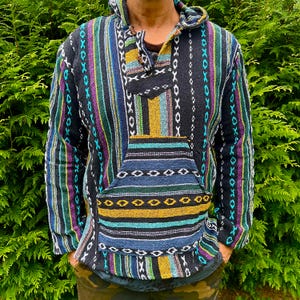 May include: A colourful striped hooded sweater with a large pocket on the front. The sweater is made of a soft, woven fabric and has a relaxed fit.