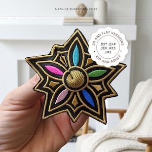 Puede incluir: Parche de hombro Rumi bordado en negro y dorado con un diseño floral. El parche presenta un círculo central dorado rodeado de pétalos coloridos en rosa, azul y verde. El texto "RUMI SHOULDER PATCH" es visible.