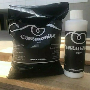 May include: Two packages of Castmonite, a resin casting product. The larger package is a black bag with white text that reads "Castmonite Base" and "Made in Australia". The smaller package is a white bottle with a black label that reads "Castmonite Liquid" and "Made in Australia".
