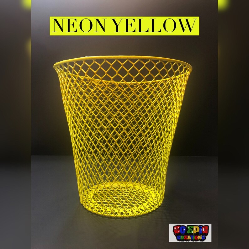 Puede incluir: Un cubo de basura de alambre amarillo ne&oacute;n brillante con un patr&oacute;n de malla en forma de diamante. El cubo est&aacute; vac&iacute;o y se encuentra sobre una superficie oscura. El texto "NEON YELLOW" est&aacute; escrito en letras negras en la parte superior de la imagen.