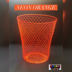 Puede incluir: Un cubo de basura de rejilla de alambre naranja ne&oacute;n brillante. El cubo tiene forma de cono y presenta un patr&oacute;n de diamante.