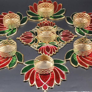 Puede incluir: Conjunto de siete candelabros de metal en forma de flor de loto de color dorado con esmalte rojo y verde. Los candelabros están dispuestos en forma circular.