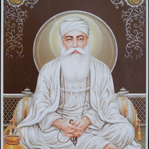 Könnte beinhalten: Ein weißbärtiger Mann mit einem weißen Turban sitzt im Schneidersitz auf einem Thron mit einem goldenen Heiligenschein hinter ihm. Er hält eine Gebetskette in seinen Händen. Der Hintergrund ist braun mit goldenen Blumendesigns und der Zahl "96" in goldenen Kreisen in den oberen Ecken.