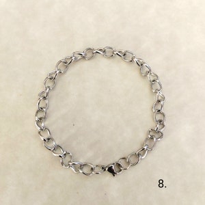 May include: A silver chain bracelet with a lobster clasp closure.