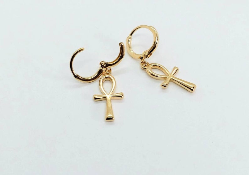 Op de afbeelding: Een paar gouden creolen met een ankh-bedel die aan elke creool hangt.
